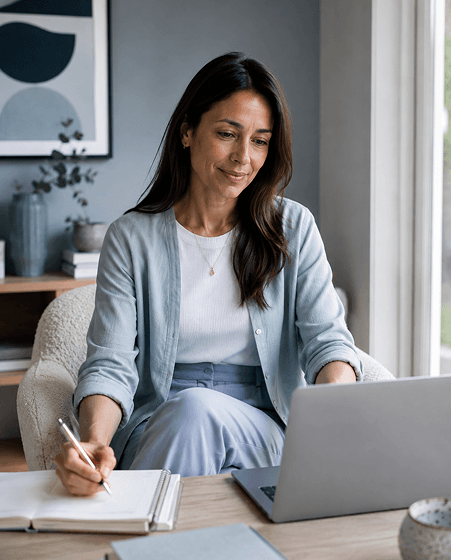 Mujer escribiendo frente a laptop